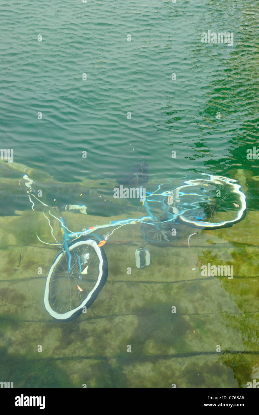 Ein geschändeter Fahrrad, das ist ins Meer geworfen worden, und liegt unter dem Wasser untergetaucht. Stockfoto