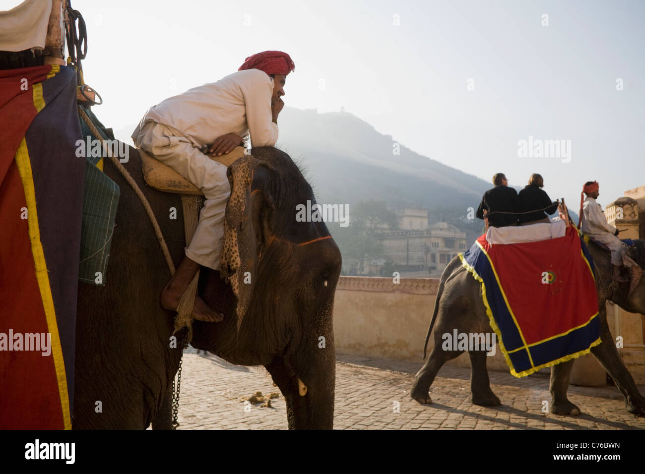 Ein Elefant Fahrer wartet seinerseits als eine weitere Touristen bis zu historischen Amber Fort in Jaipur, Indien Rajasthan Zustand bringt Stockfoto