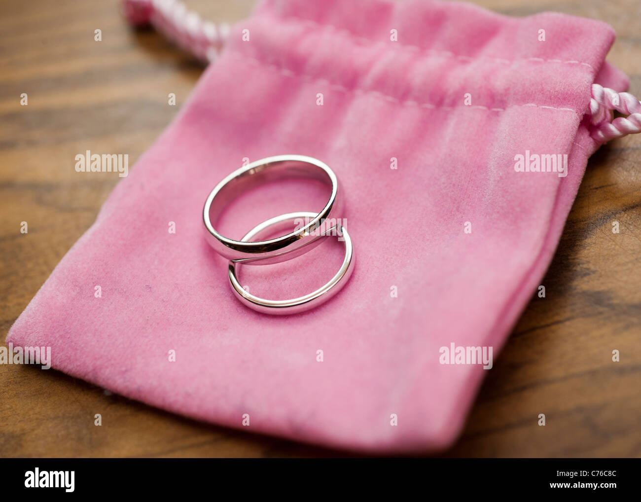 Ein paar Weissgold Trauringe auf ein rosa Beutel am Tag der Hochzeit, uk Stockfoto