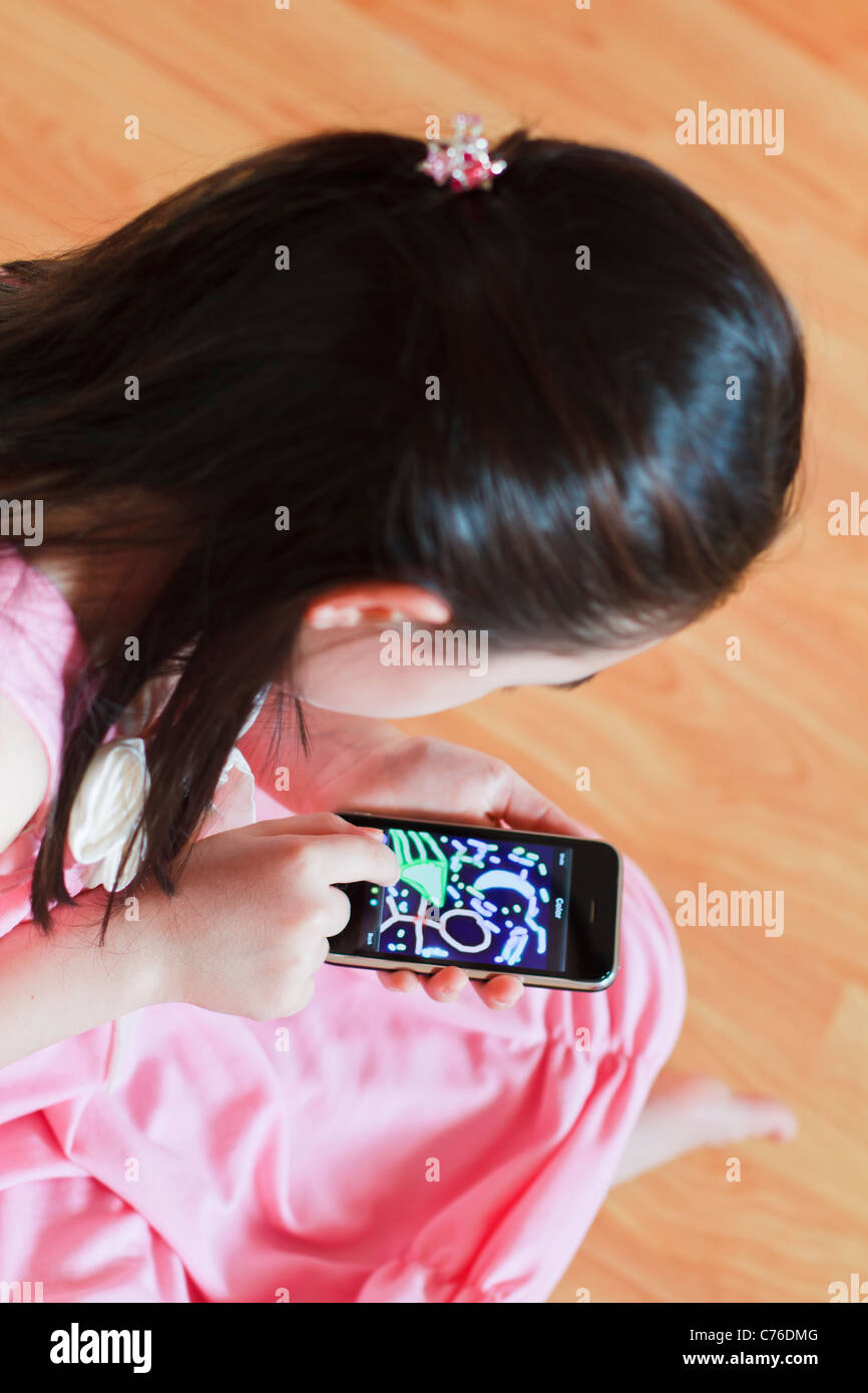 Kleines Mädchen, gestützt auf moderne Touchscreen-Telefon Stockfoto