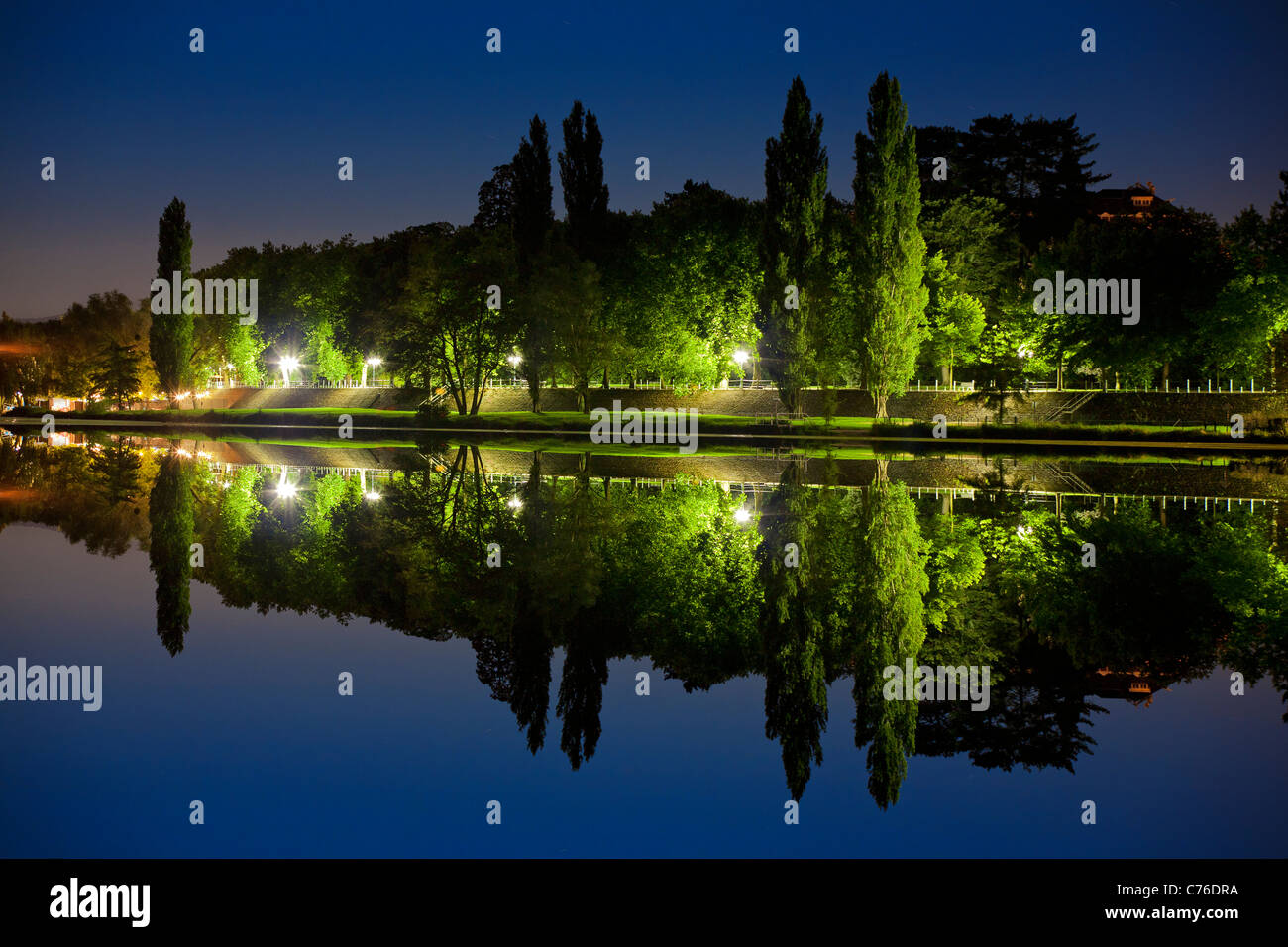 In der Nacht, ein Blick auf einen Park am Fluss gespiegelt wird. Vue de Nuit d ' un Parc Se Reflétant Dans Une Rivière. Stockfoto