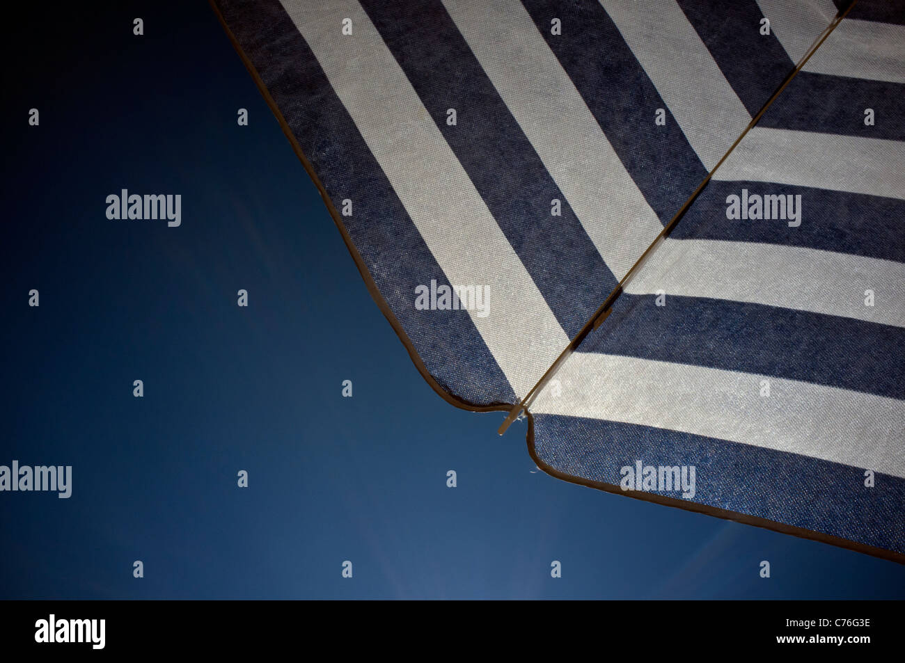 Unter einer blau-weißen abgespeckte Sonnenschirm Regenschirm Stockfoto
