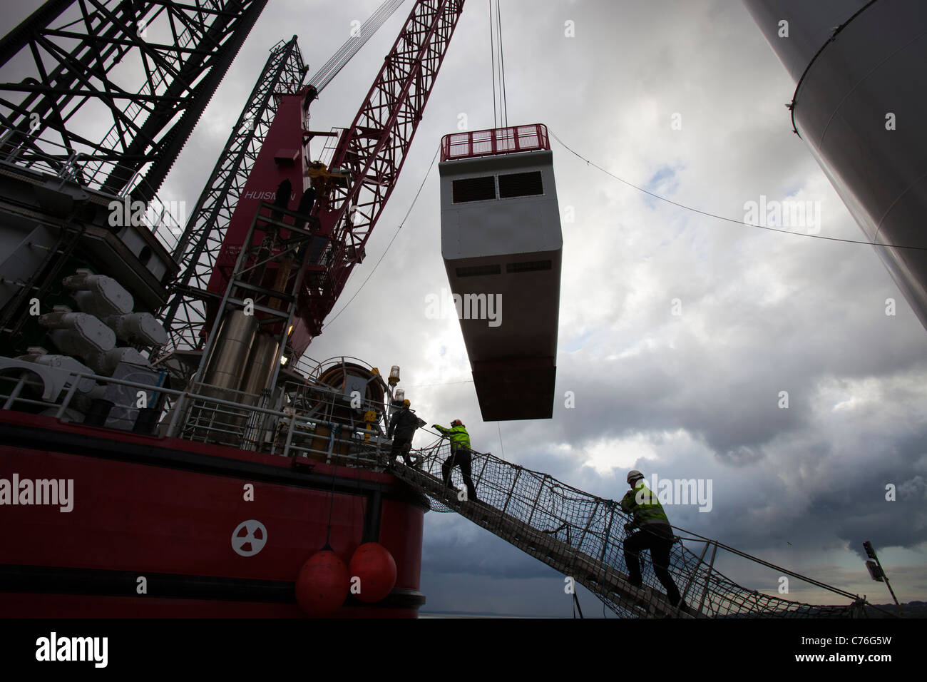 Arbeiter heben eine Gondel für eine Windkraftanlage auf einem Aufbocken Lastkahn, für den Offshore-Windpark Walney. Stockfoto