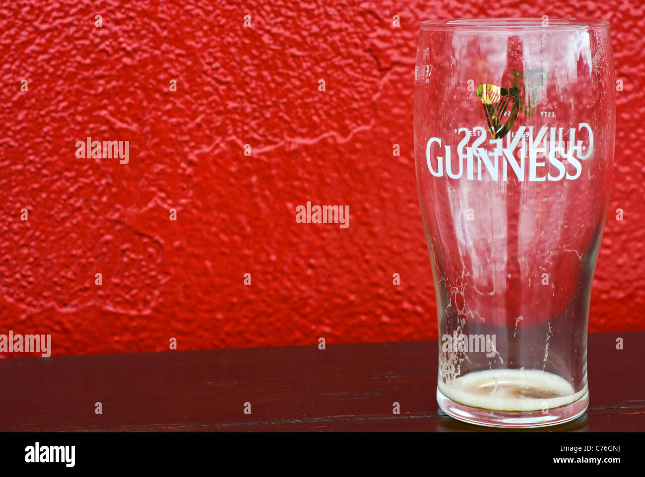 Ein leeres Guinness Glas auf einem Tisch vor einem Pub in County Cork, Irland Stockfoto