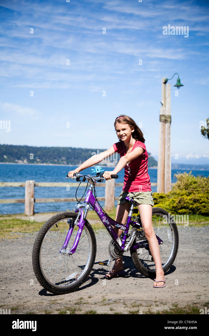 Ein Porträt des jungen Mädchens mit dem Fahrrad an einem sonnigen Nachmittag. Stockfoto