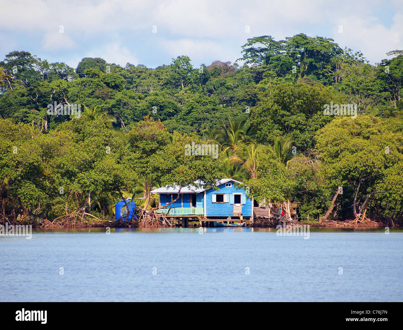 Küste mit einem rustikalen Haus auf Stelzen über dem Wasser und üppige tropische Vegetation, Archipel Bocas del Toro, Panama, Mittelamerika Stockfoto