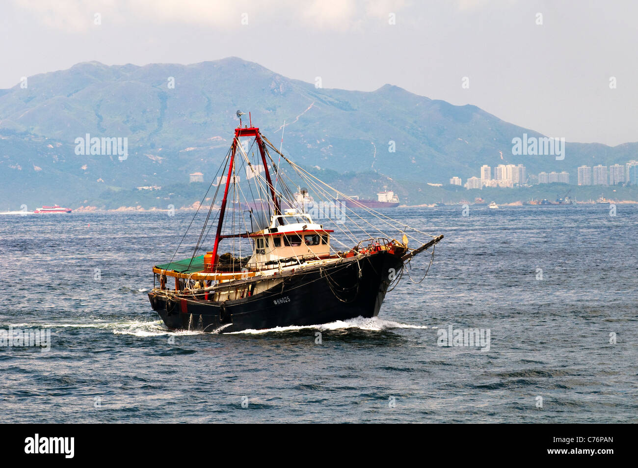 Ein chinesisches traditionelles Fischerboot in das Südchinesische Meer. zwei große Fischernetze sind von beiden Seiten des Bootes gesunken. Stockfoto