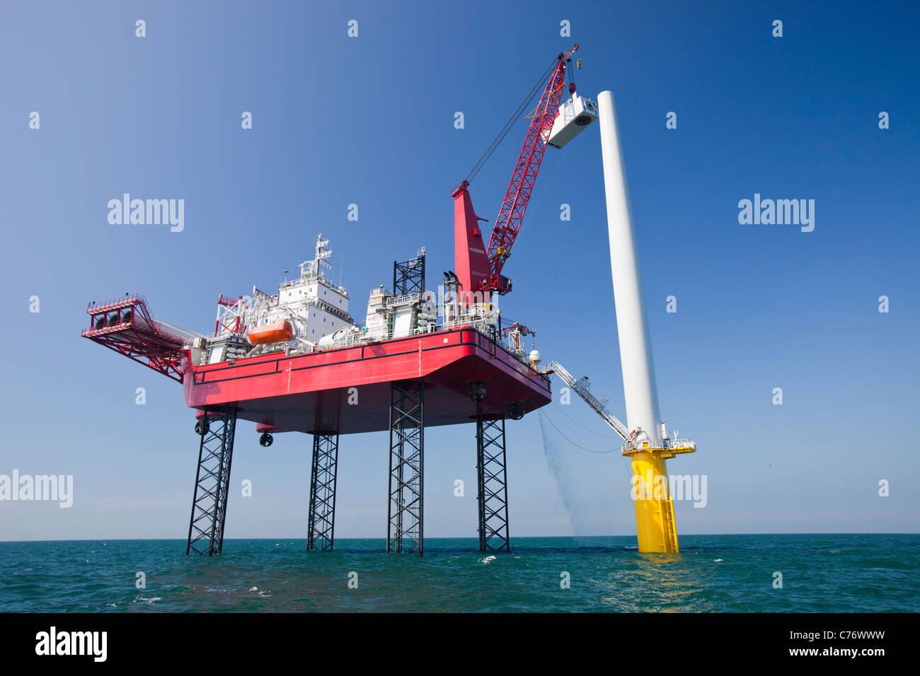 Ein Aufbocken Lastkahn hebt eine Gondel auf Turm einer Windkraftanlage im Walney Offshore-Windpark, Cumbria, England. Stockfoto