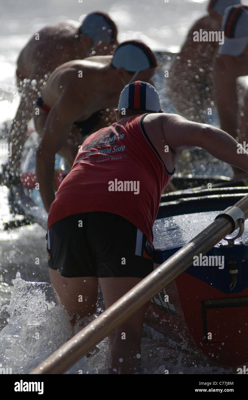 Während ein Surf-Karneval Rettung der Besatzung ein Surf Boot klettern an Bord ihres Schiffes zu Beginn eines Rennens. Stockfoto