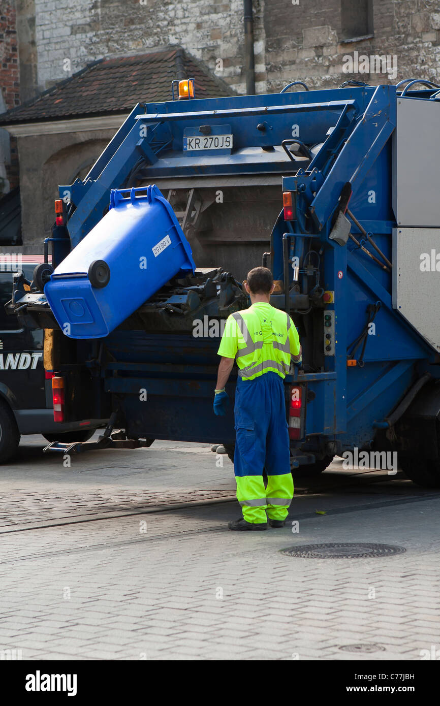 Sauberer Arbeitnehmer während der Arbeit an der Straße mit Müll-Sammlung-LKW. Krakau, Polen. Stockfoto