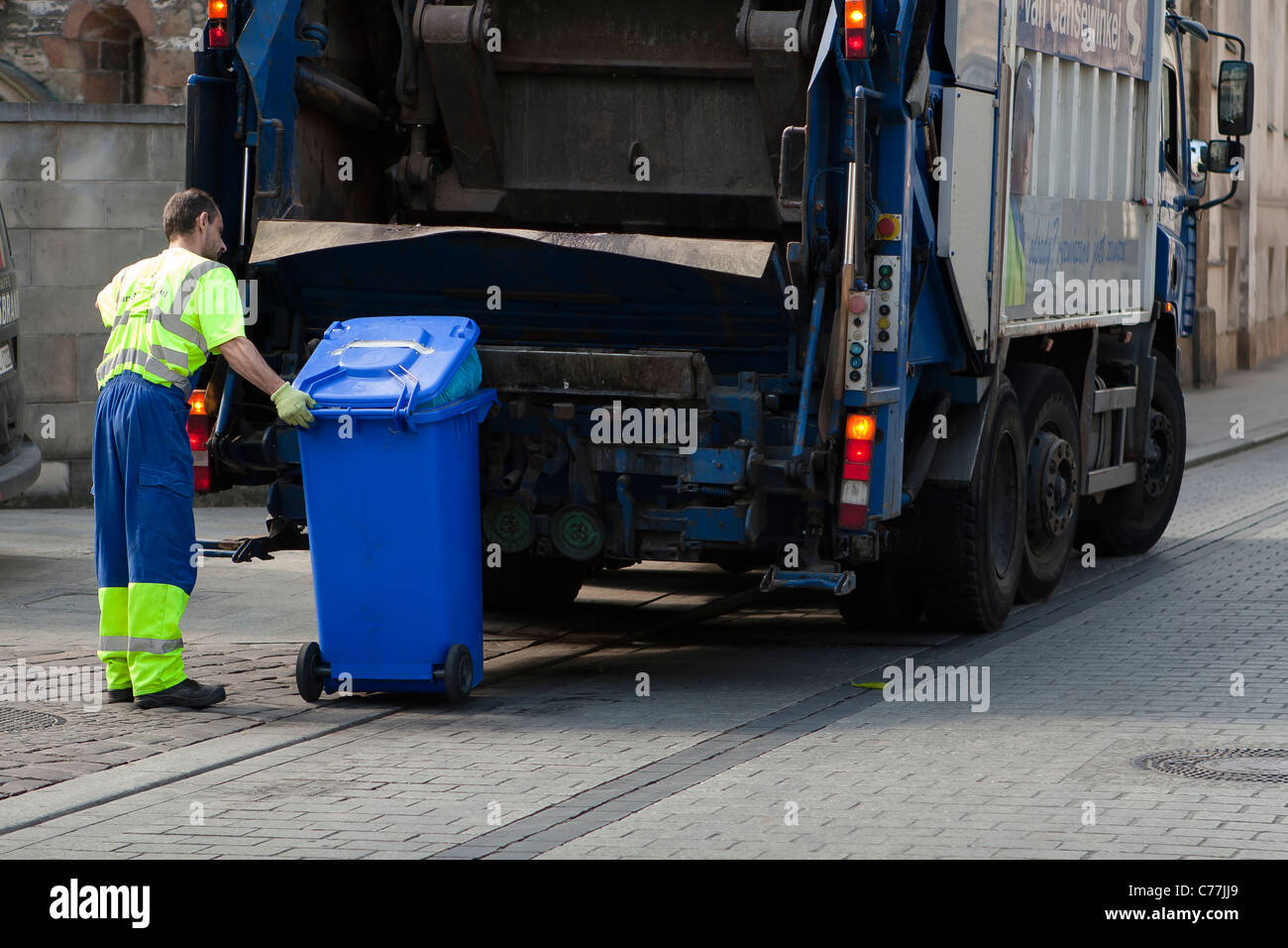 Sauberer Arbeitnehmer während der Arbeit an der Straße mit Müll-Sammlung-LKW. Krakau, Polen. Stockfoto