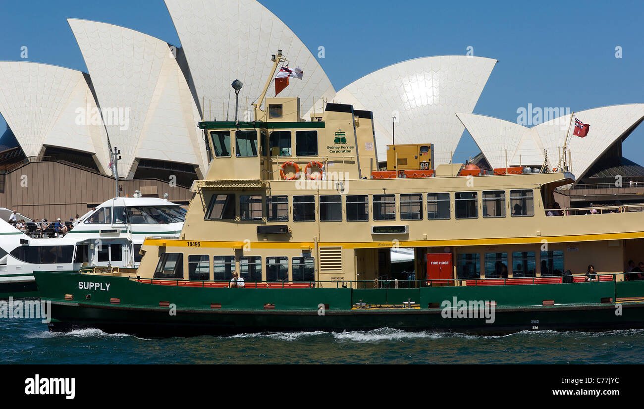 Eine Fähre und ein Hafen Kreuzfahrt Schiff Pass vor das Symbol von Australien, Sydney Opera House, in der Nähe von Circular Quay. Stockfoto