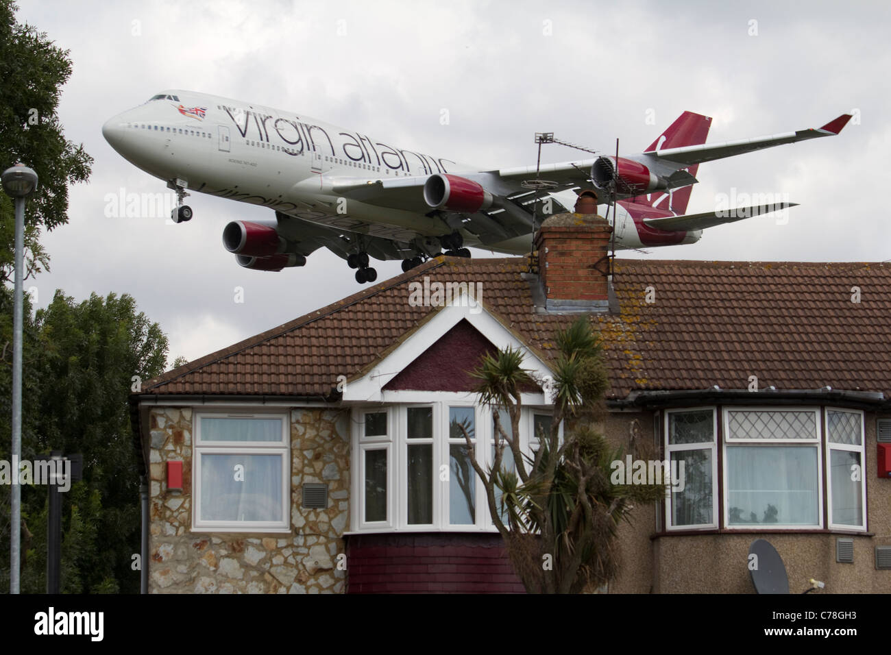 Niedrig fliegende Flugzeuge Heathrow Flughafen Ansatz Virgin Atlantic, Lärmbelästigung mit Wohnungsbau Stockfoto