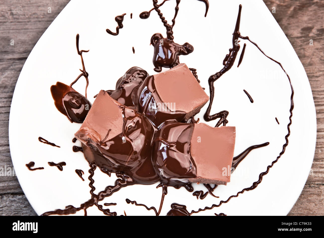 glatte Schokoladenstücke mit Schokoladensauce Stockfoto