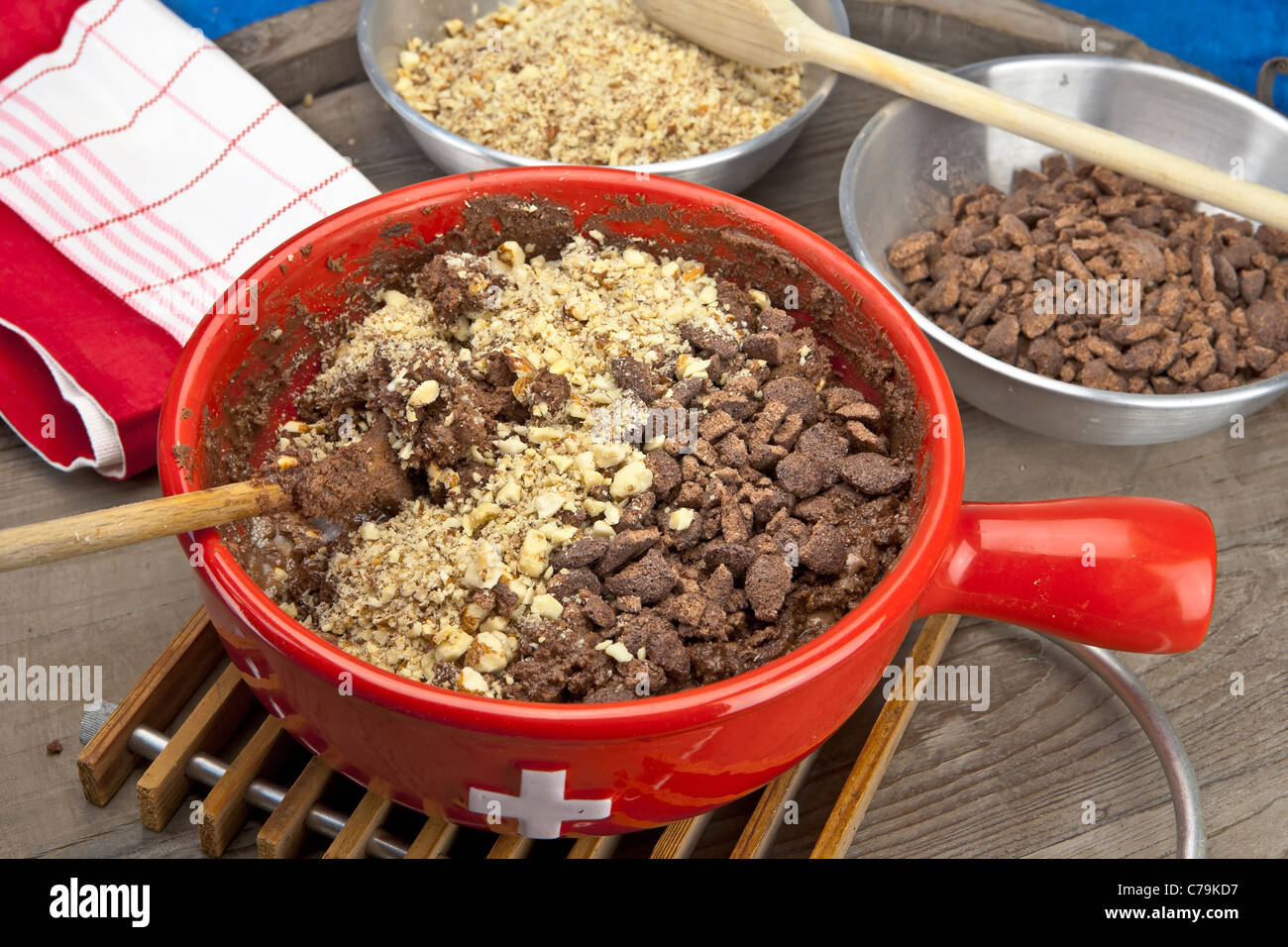 Schoko Cornflakes und Muttern werden mit geschmolzener Schokolade gemischt. Stockfoto
