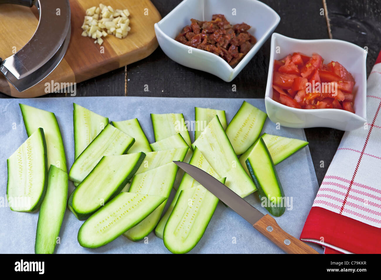 frische Zutaten wie Zucchini, Tomaten, getrockneten Tomaten und Pinienkernen für einen Salat Stockfoto