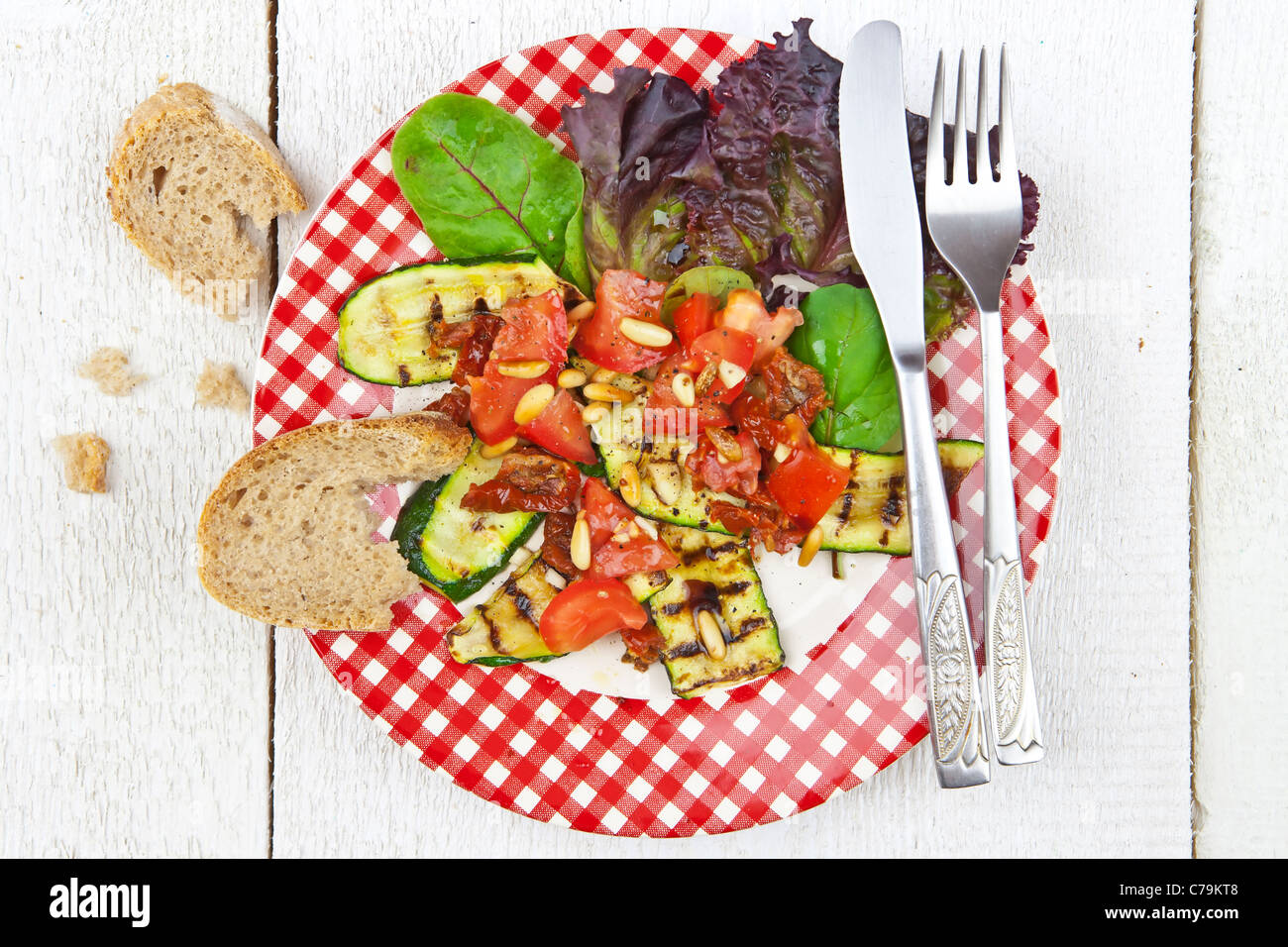 Salat mit gegrillten Zucchini, Tomaten und Pinienkernen Stockfoto