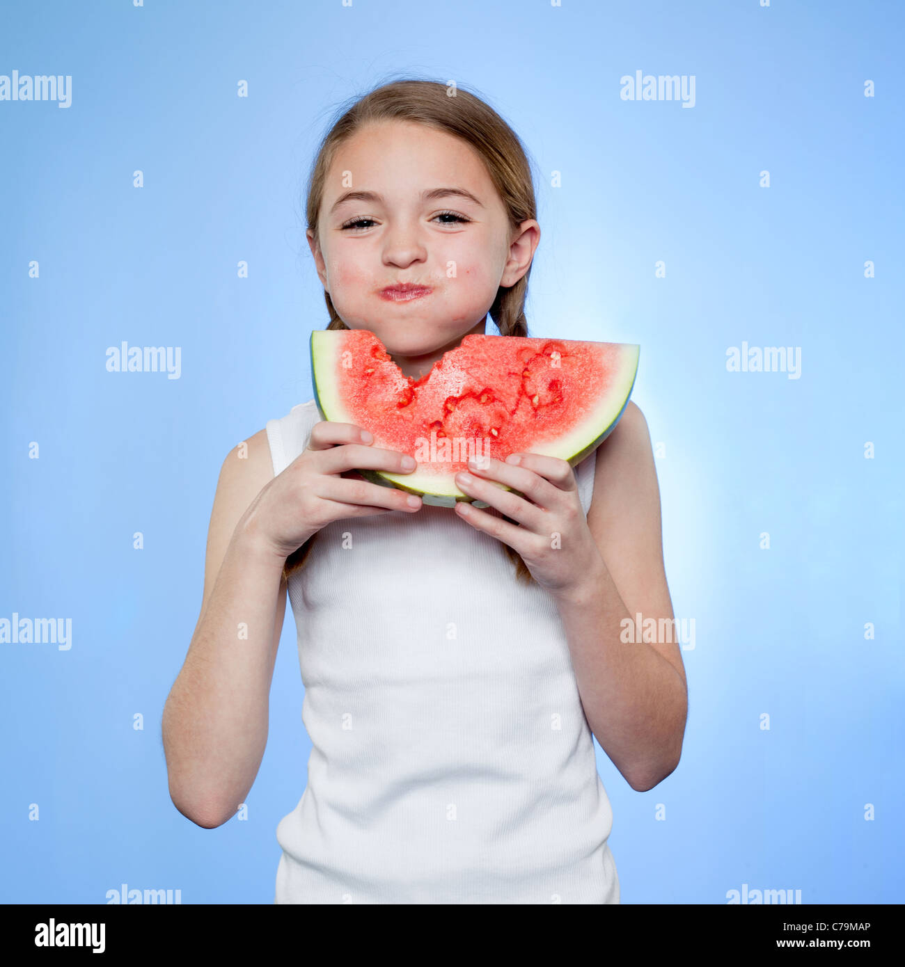 Studioaufnahme von Mädchen (10-11) Essen Wassermelone Stockfoto