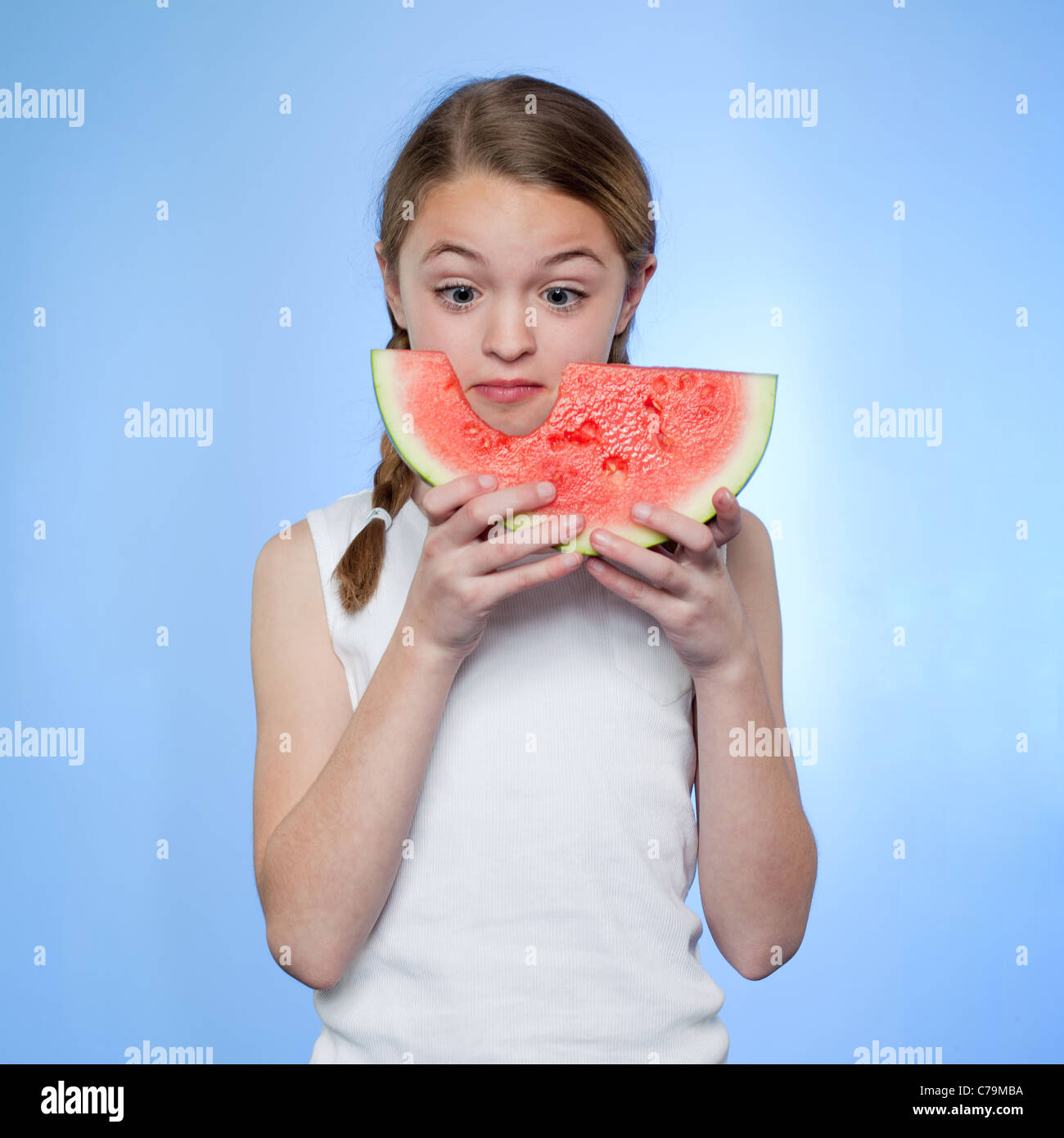 Studio shot der Mädchen (10-11) Holding Scheibe Wassermelone Stockfoto