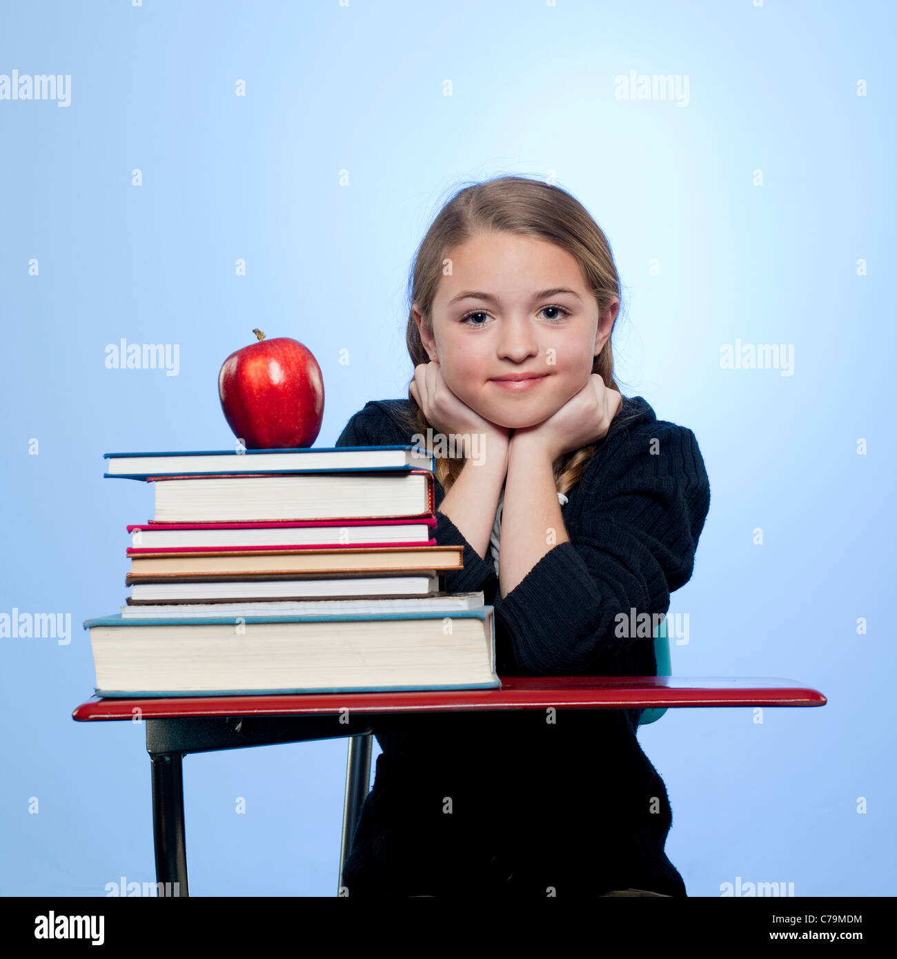 Studio-Porträt eines Mädchens (10-11) mit Stapel von Büchern und Apfel Stockfoto