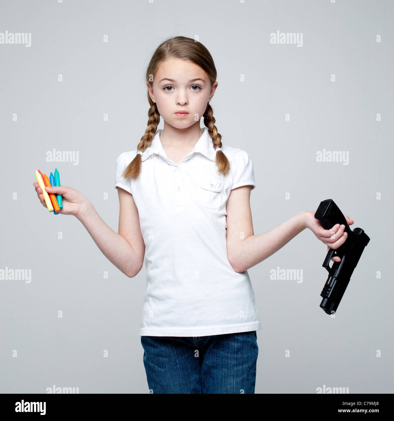 Studioaufnahme von Mädchen (10-11) Holding Pistole und Buntstifte Stockfoto