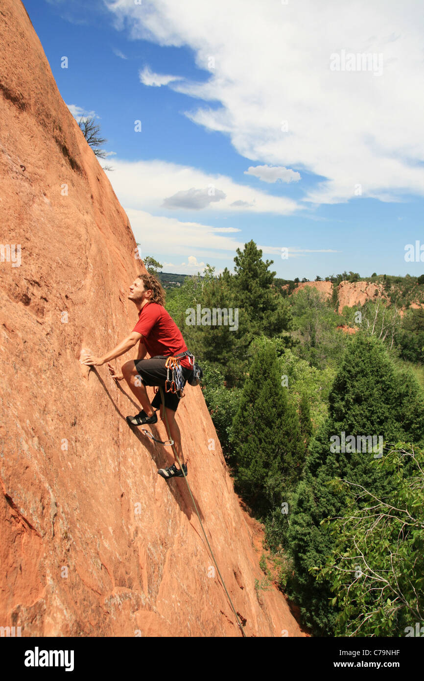 ein Mann in der roten Führung auf einem Sandstein Platte Klettern Stockfoto