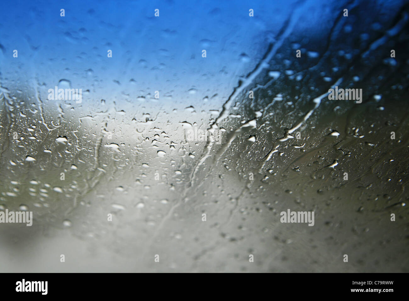 Blick durch einen nassen Windschutzscheibe mit flachen Schärfentiefe und Fokus auf die Wassertropfen Stockfoto