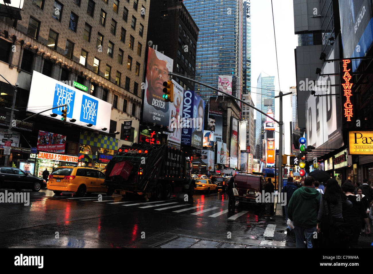 Nassen Asphalt Regen Reflexion Autos gelben taxis Müll Wagen Neon Werbung Wolkenkratzer 7th Avenue, Richtung Times Square in New York City Stockfoto