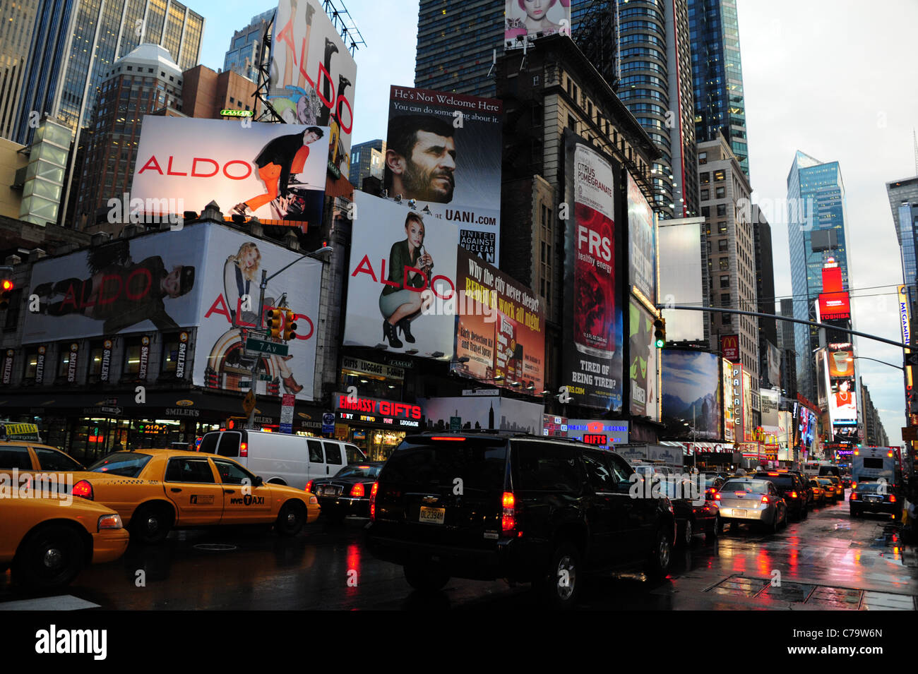 Verkehr (Autos, die gelben Taxis) Schlange roten Neon nassem Asphalt 7th Avenue vorderen Wolkenkratzer in Richtung Times Square in New York City anzeigen Stockfoto