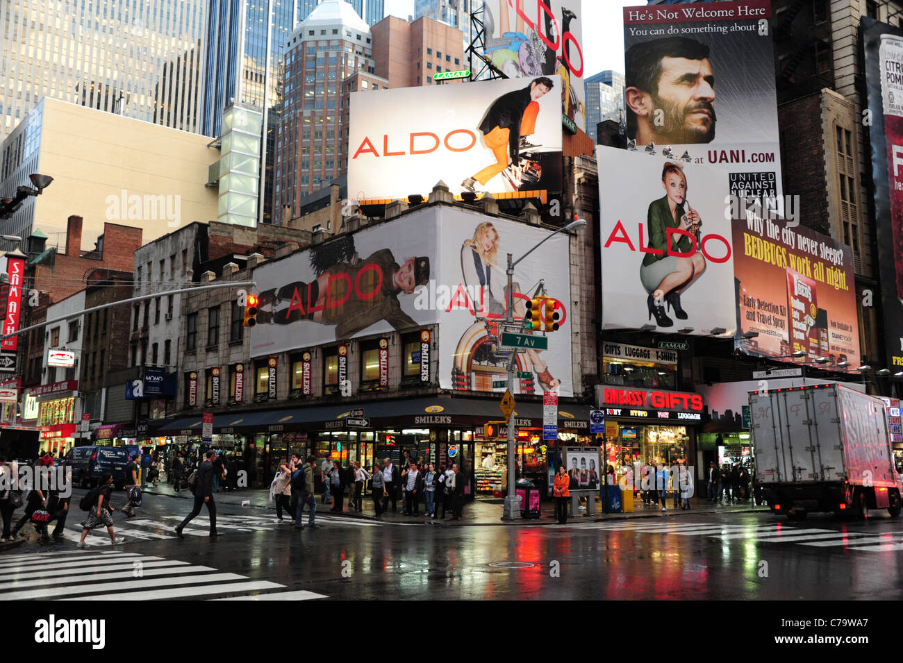 Regen Ansicht Neonlichter, beleuchteten Geschäfte, Menschen, Plakat-Werbung, Ecke 7th Avenue West 48th Street, New York City, USA Stockfoto