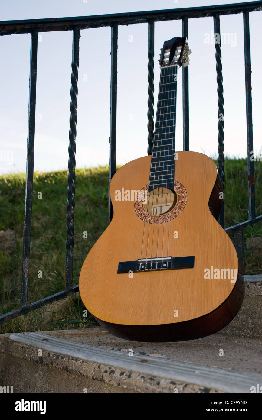 Eine akustische Gitarre gegen ein Geländer gelehnt im Freien. Stockfoto