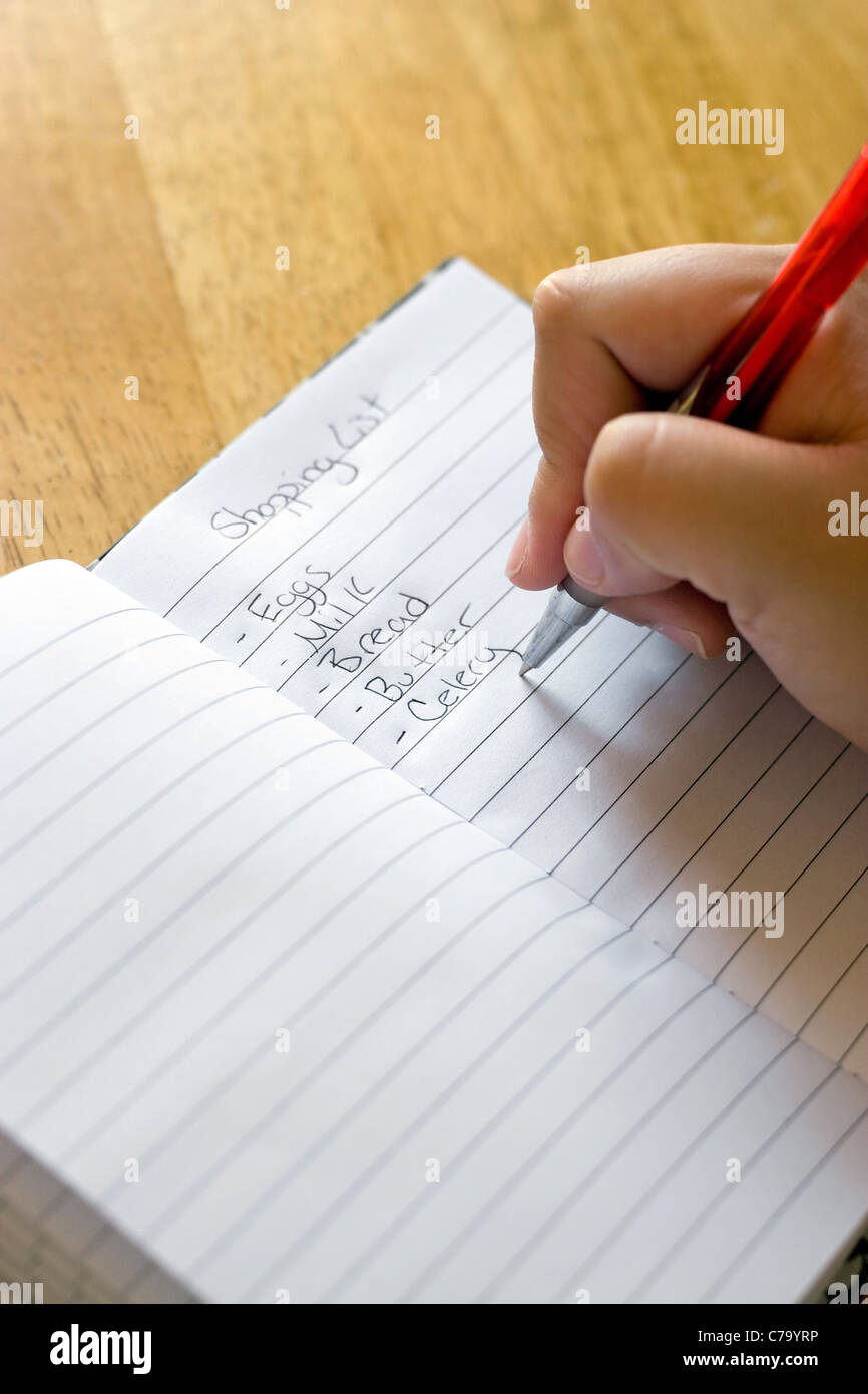 Eine Nahaufnahme von jemandem ihre Grocery Einkaufsliste zu schreiben. Stockfoto