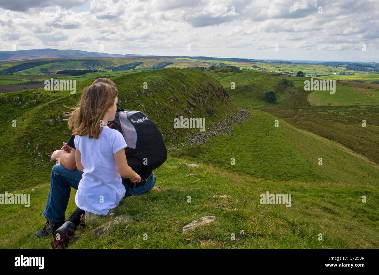 Vater & Tochter eine Pause während des Gehens Hadrian Mauerweg in der Nähe von Walltown Klippen, Northumberland (Blick West) Stockfoto