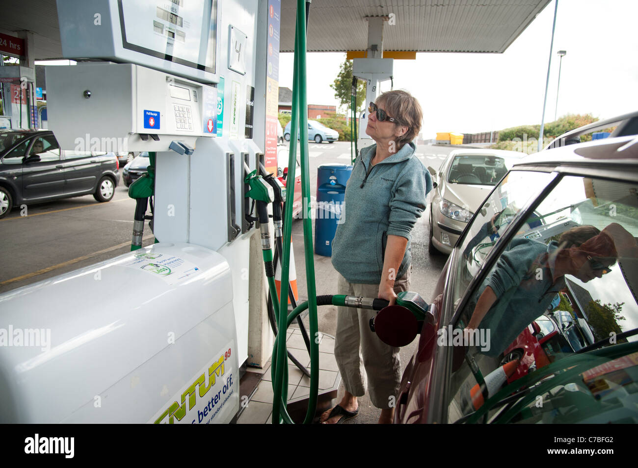 Eine Frau, die ihr Auto Einfüllen von Benzin an einem Seitenarm des Tesco, UK Stockfoto