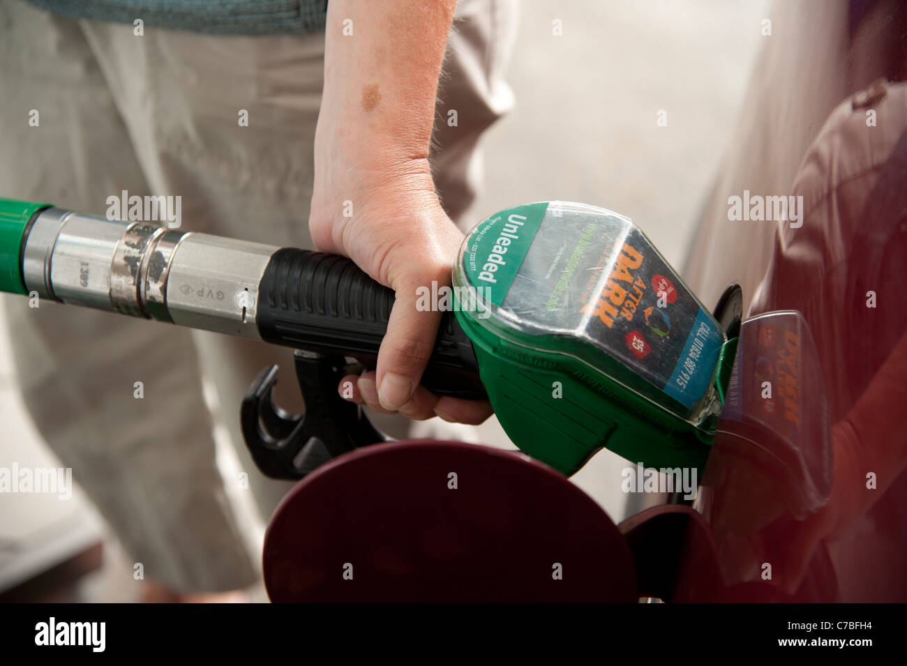 Eine Frau, die ihr Auto Einfüllen von Benzin an einem Seitenarm des Tesco, UK Stockfoto