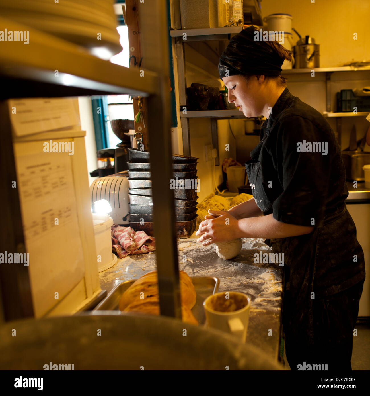 Eine Frau, die Herstellung von Brot Brötchen in The Treehouse Bio vegetarisches Café Restaurant, Aberystwyth Wales UK Stockfoto