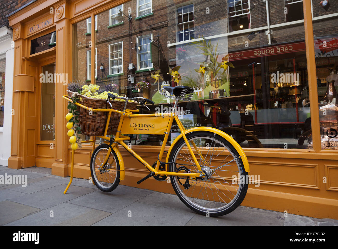 Alten Stil gelb Kaufmann Fahrrad vor Geschäft in York, England Stockfoto