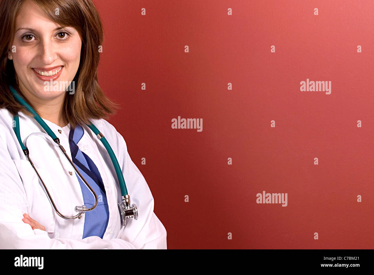 Eine lächelnde junge Arzt isoliert über rot mit Exemplar. Stockfoto