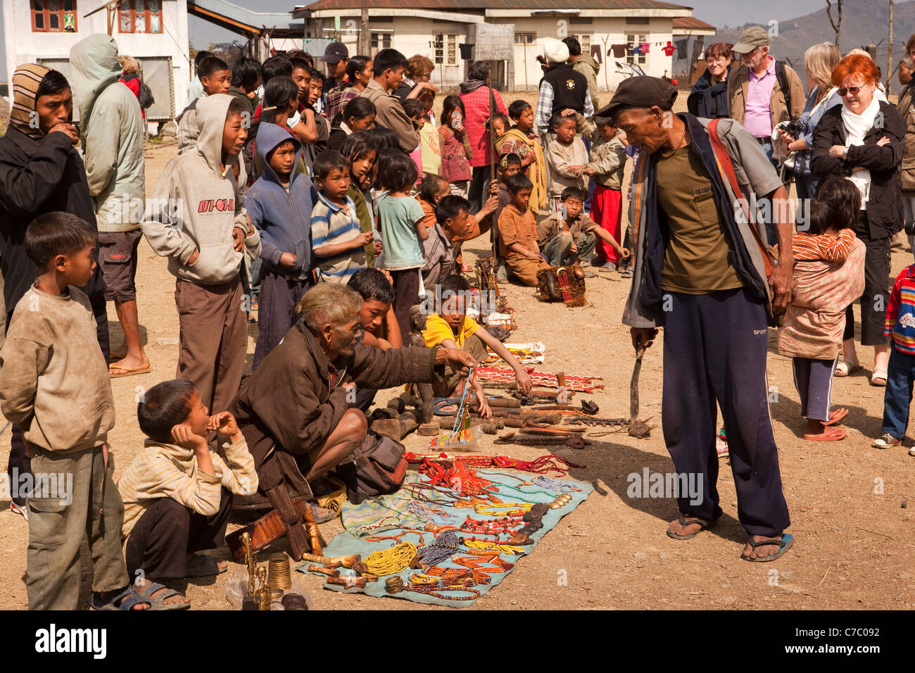 Indien, Nagaland, Longwa, Konyak Naga Dorfbewohner lokales Kunsthandwerk an westliche Touristen verkaufen Anzeigen Stockfoto