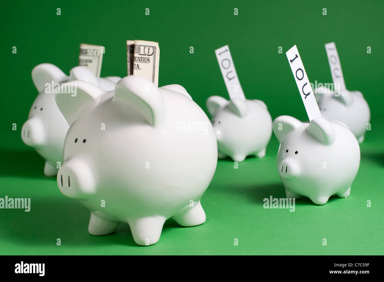 Sparschweine mit IOU und Geld aus Münzschlitze Stockfoto