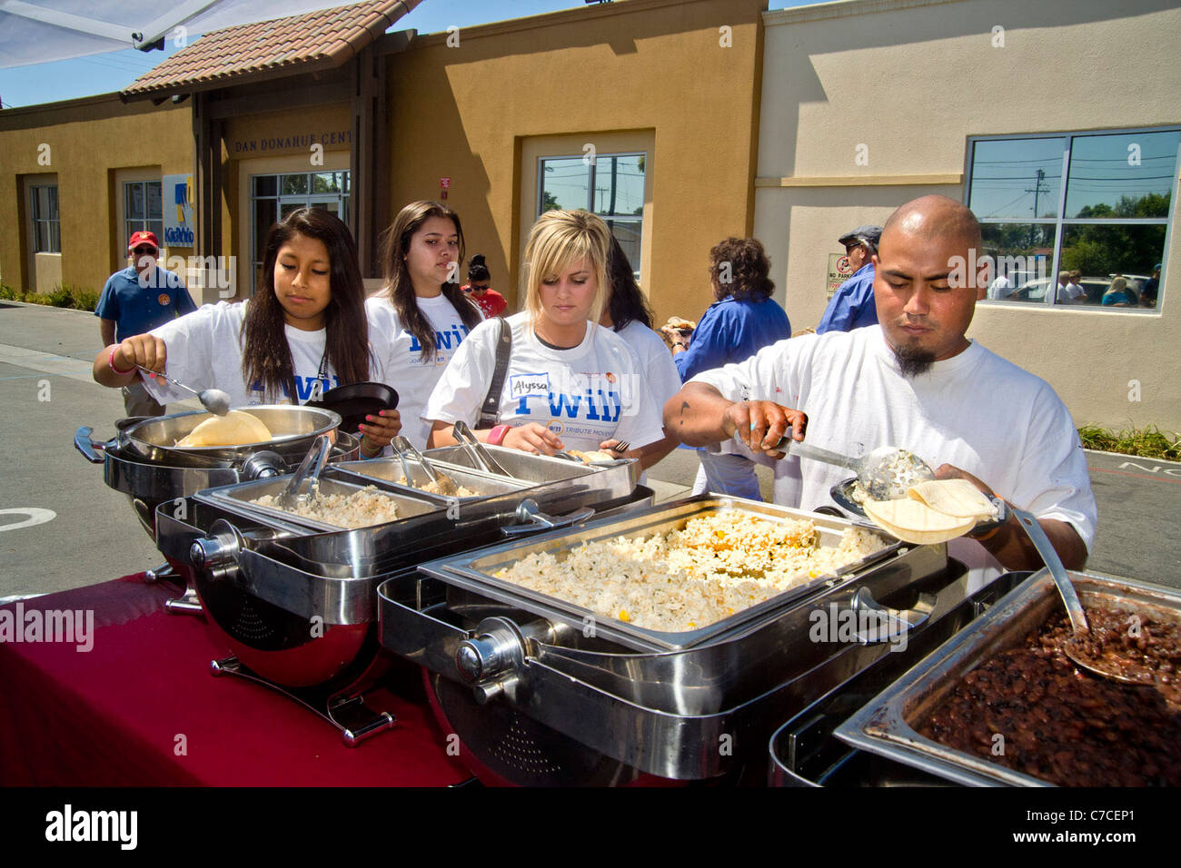Jungen Erwachsenen Freiwilligen im Logo T-shirts Mittagessen auf mexikanisches Essen auf ein Gemeinschaftsprojekt Verschönerung in Santa Ana, Kalifornien. Stockfoto