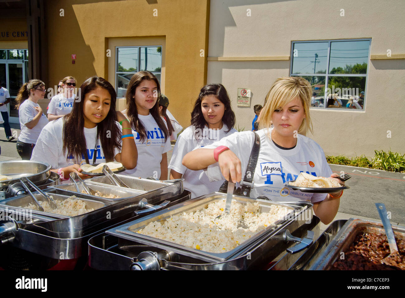Jungen Erwachsenen Freiwilligen im Logo T-shirts Mittagessen auf mexikanisches Essen auf ein Gemeinschaftsprojekt Verschönerung in Santa Ana, Kalifornien. Stockfoto