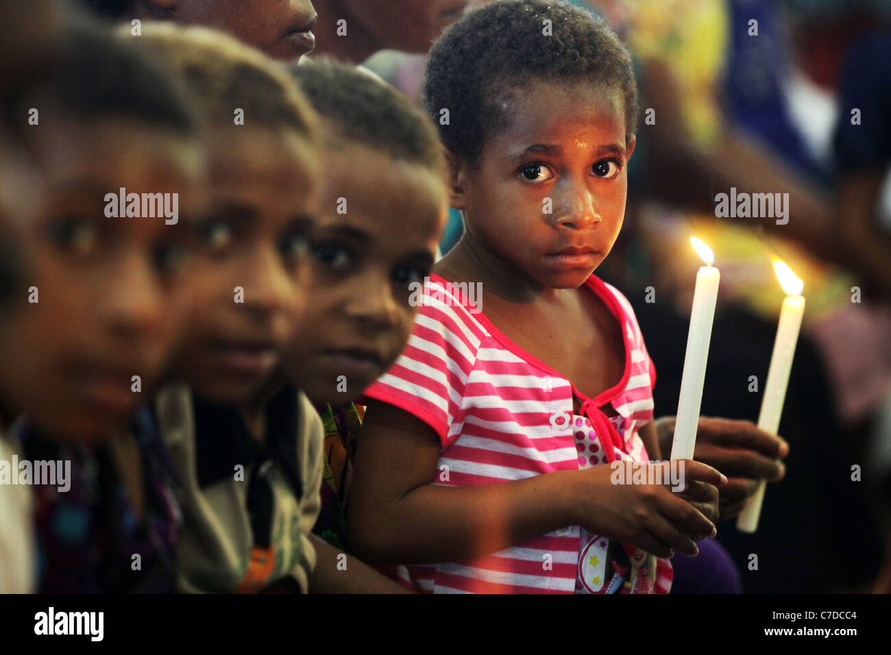 junges Mädchen mit Kerzen in einer Kirche in Kiunga, Papua-Neu-Guinea Stockfoto