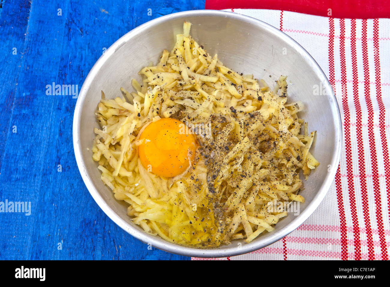 geriebene Kartoffeln mit rohem Ei in einer Schüssel Stockfoto