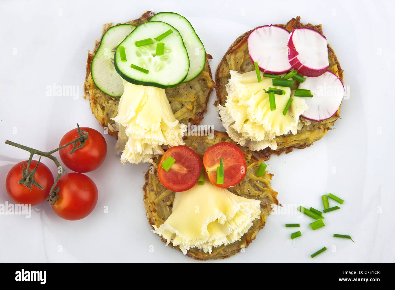 Kartoffeln aus dem Ofen, serviert mit Tete de Moine Käse und garniert mit Tomaten, Gurken und Radieschen Stockfoto