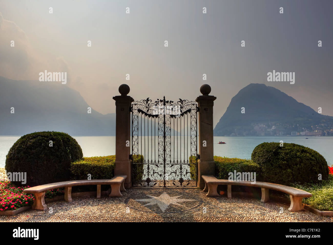 Tor in den Parco Civico Villa Ciani mit Blick auf den Luganer See und Monte Salvatore Stockfoto