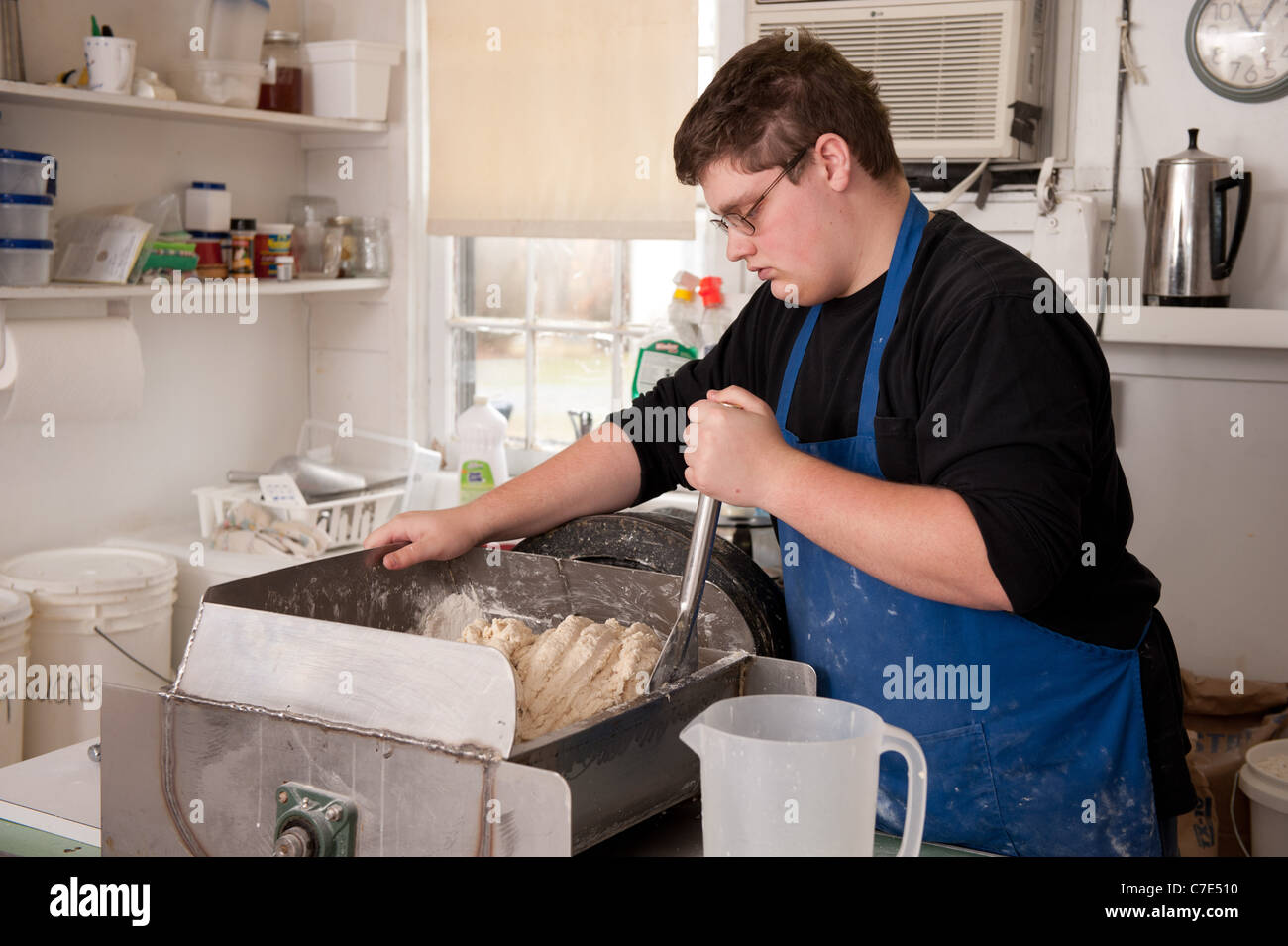 junger Mann rollenden Teig in den Prozess der Herstellung ausgetretenen Kekse Stockfoto