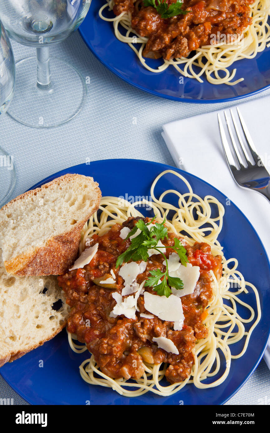 Zwei blaue Platten brach Nudeln mit Hackfleischsoße und Parmesan und Baguette Stockfoto