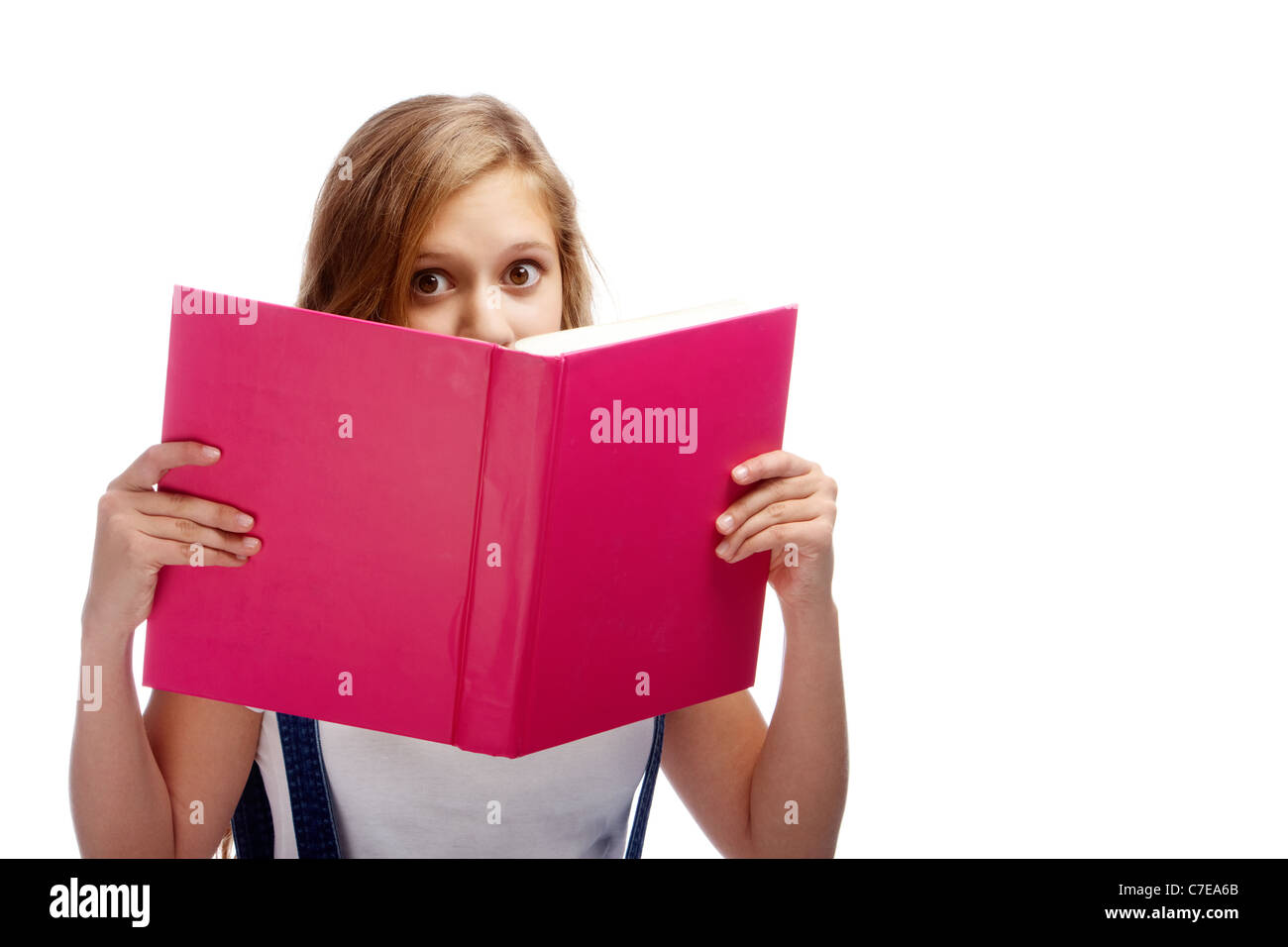Niedliche Mädchen spähte aus aufgeschlagenen Buches während reding es isoliert Stockfoto