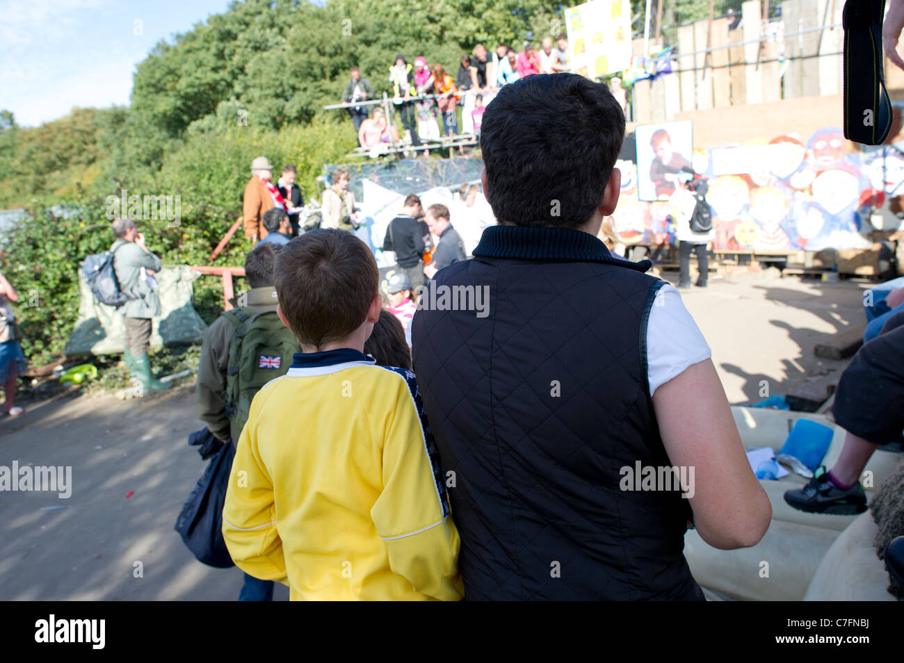 Zwei Reisende Kinder von Dale Farm schauen auf als Medien und Anhänger der Reisende warten durch das Tor zur Website für Gerichtsvollzieher. Stockfoto